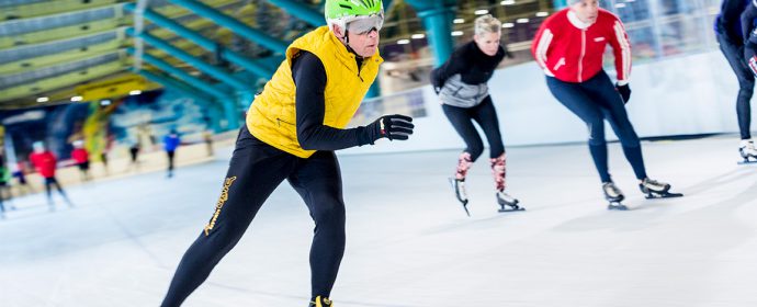 Personen schaatsen op schaatsbaan